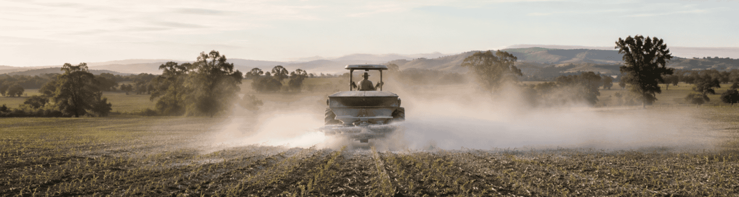 Landwirt bringt feinen Kalkstaub auf einem Feld aus – sichtbarer natürlicher Schutz für Boden und Pflanzen.